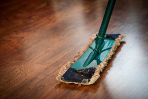 sweeping a wooden floor with a broom