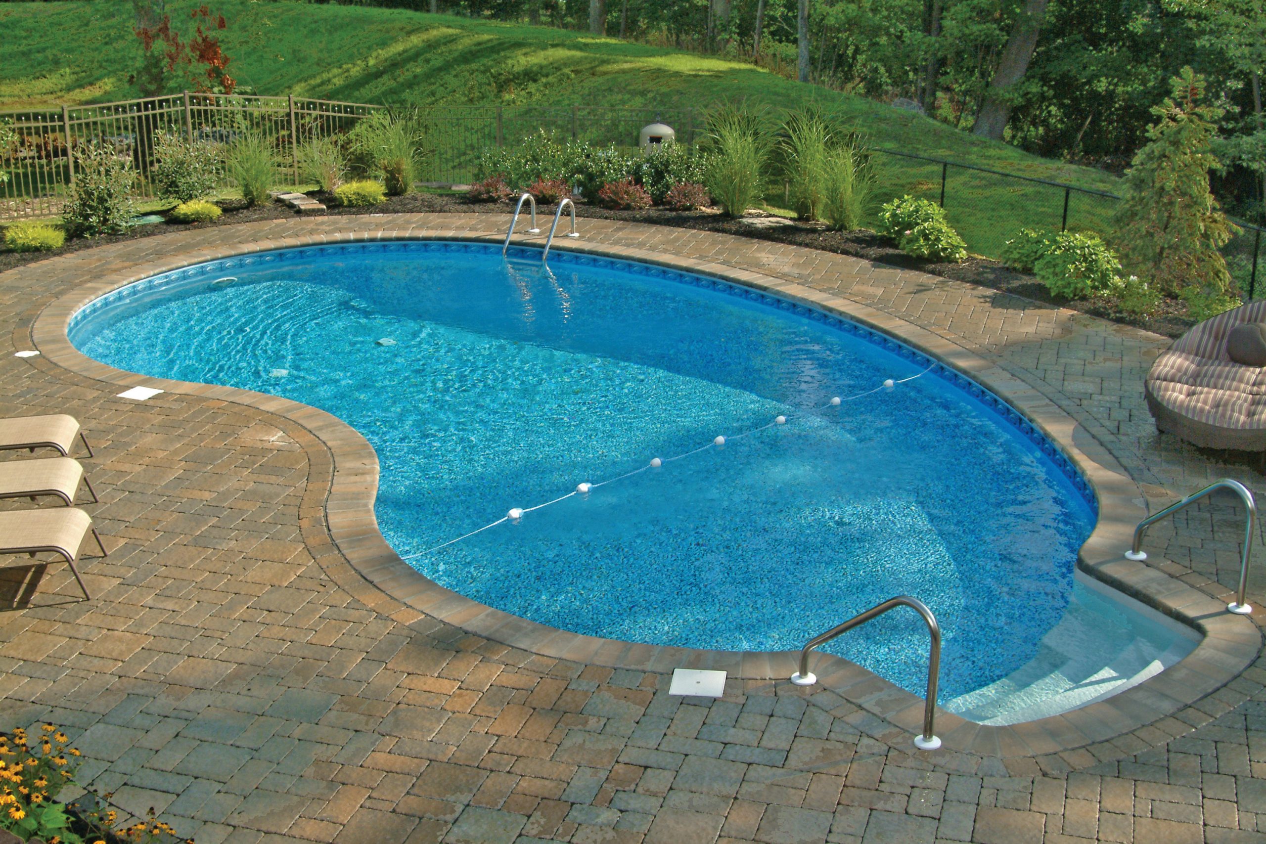 A kidney-shaped inground vinyl pool